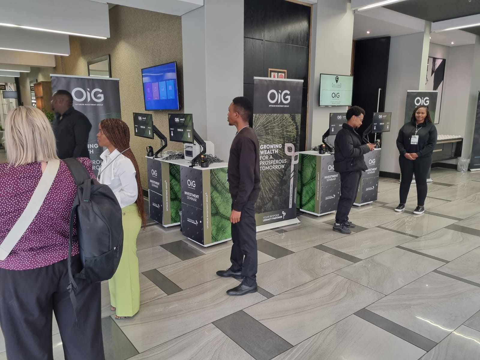 OIG Investment Seminar 2025 registration kiosks with guests and onsite staff